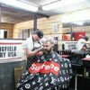 Nate Parker, professional barber, gives Jeremy Scott of Golden City a trim of the hair and beard at his newly opened shop, “Lone Wolf Barber,” located on Main Street in Lockwood. (Photo by James McNary)