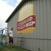 Artist Troy Freeman proofreads his work as he paints new “Certified Angus Beef” signage for the Farm Shop at Gleonda Farms. The new sign is the fourth provided by the American Angus Association to a site in Missouri. (Photos by James McNary)